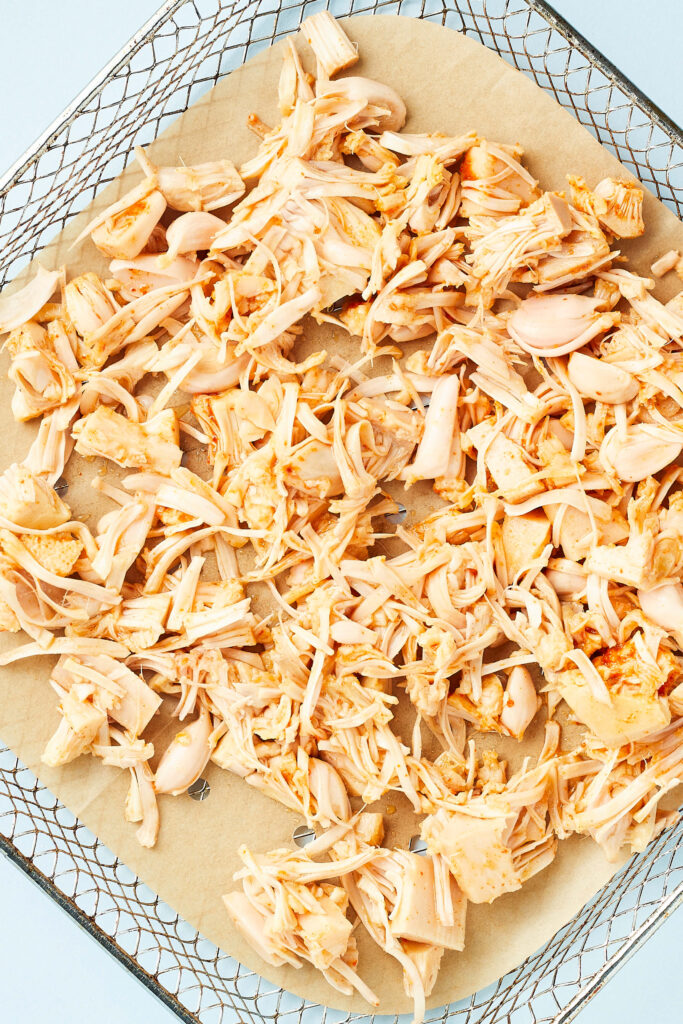 shredded and seasoned jackfruit on air fryer tray