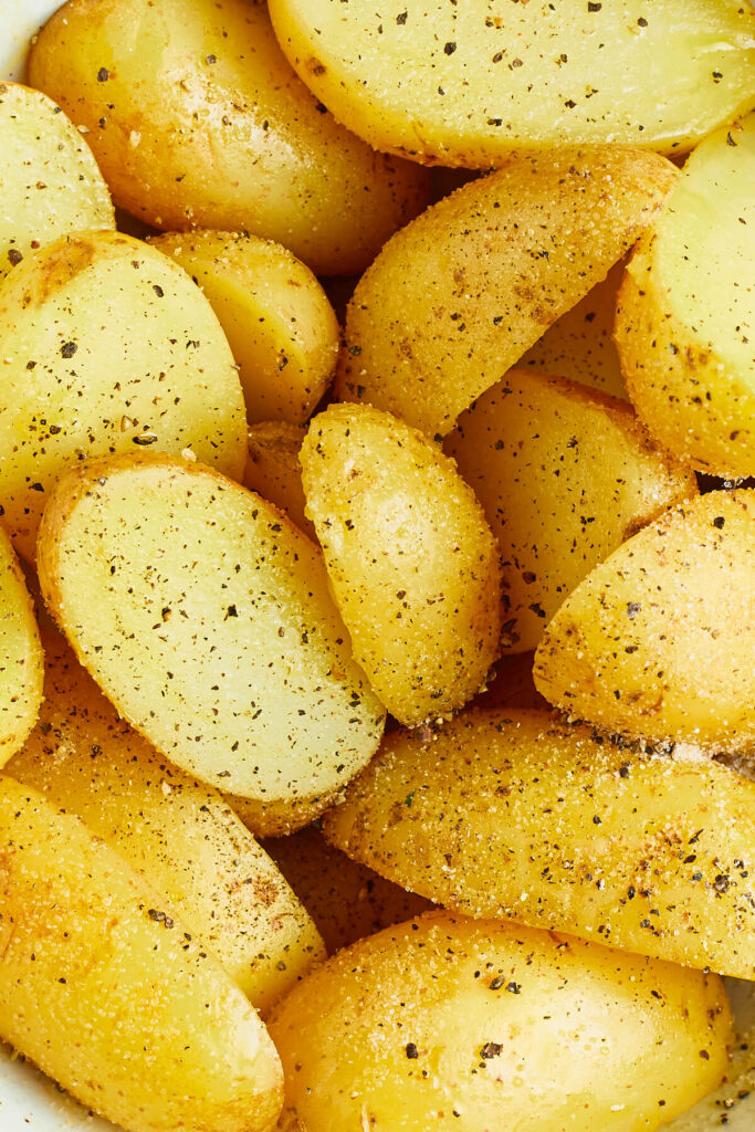 Halved and seasoned potatoes