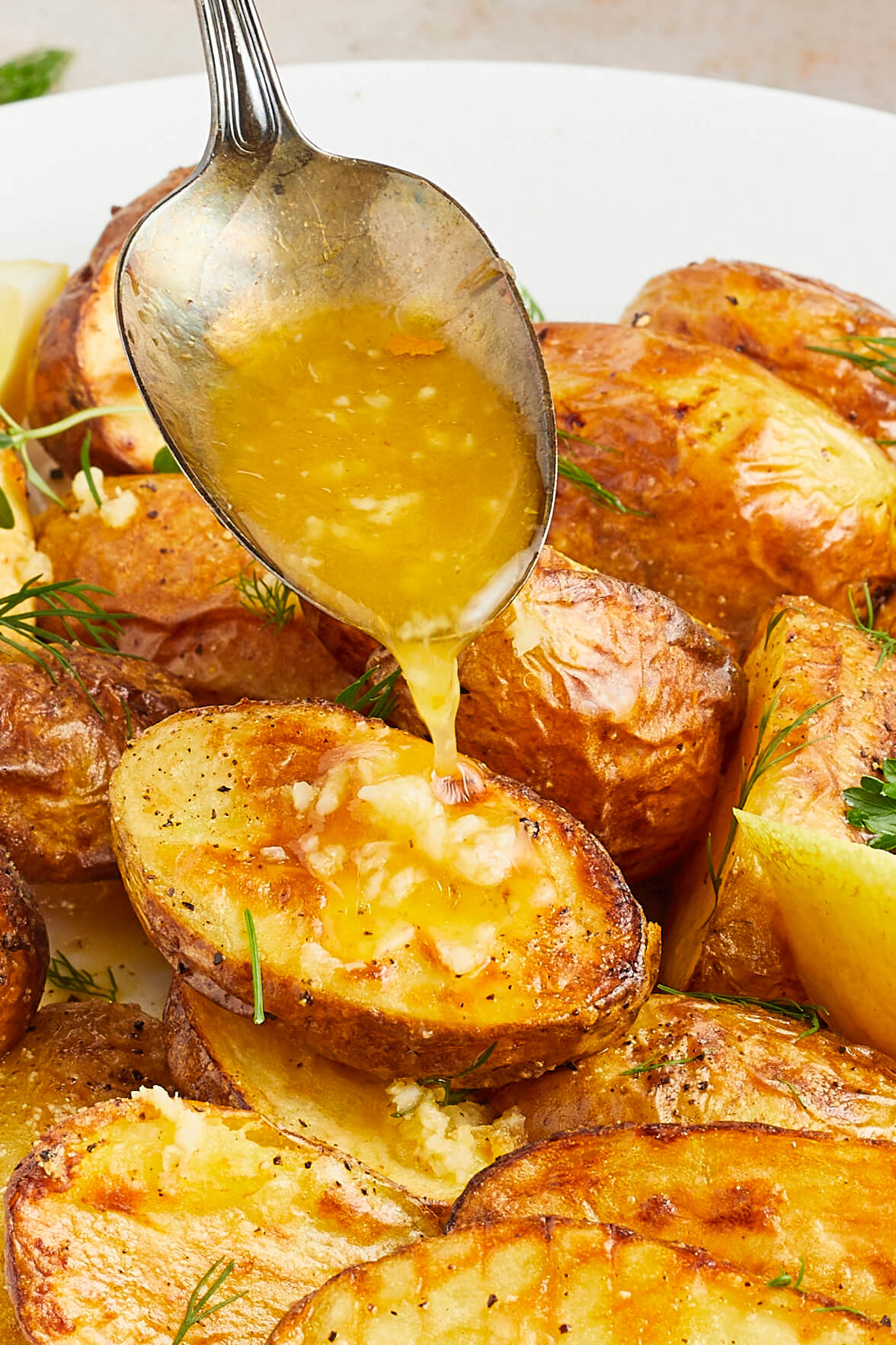Lemon Roasted Potatoes being drizzled with sauce