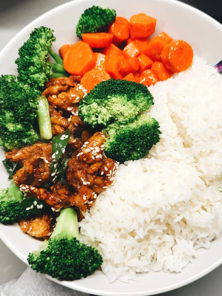 Saucy Sesame Soy Curls in a bowl with white rice, carrots, and broccoli